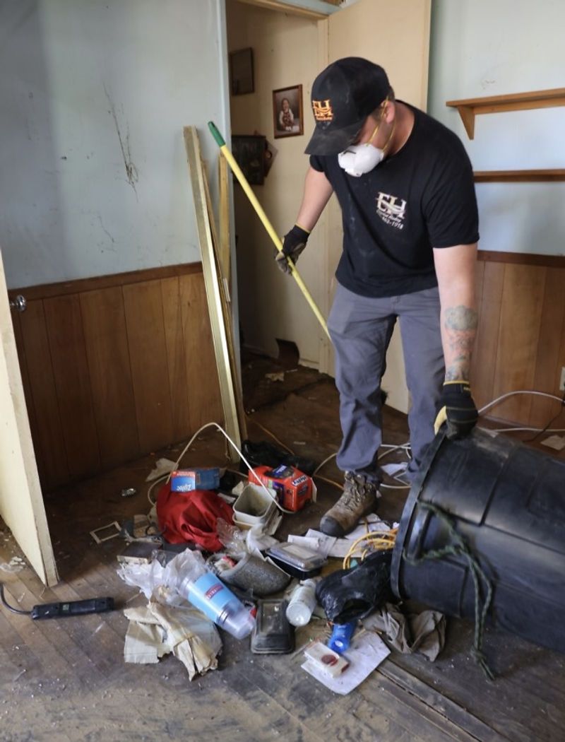 Crew member clearing junk during an eviction cleanout