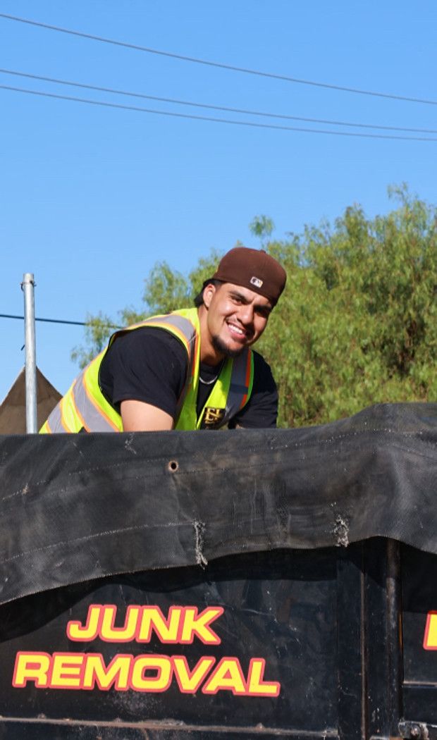 Smiling Essential Hauling crew member on the junk removal trailer